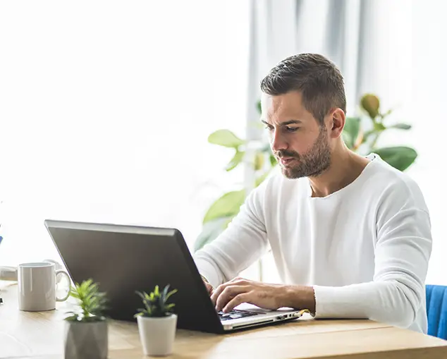 Homme réalisant la comptabilité de sa SCI sur son ordinateur portable