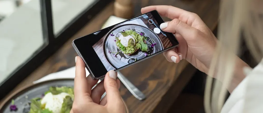 Une restauratrice qui en prend en photo son plat pour réaliser la communication de son restaurant.